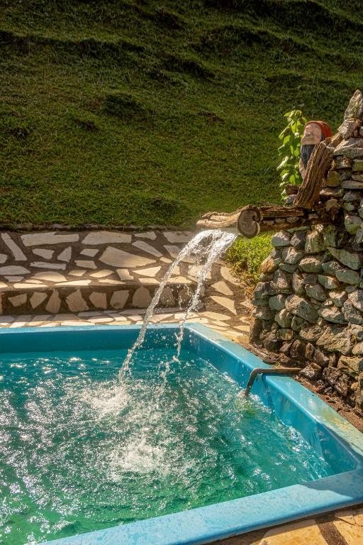 Piscina de água natural com bica de pedra